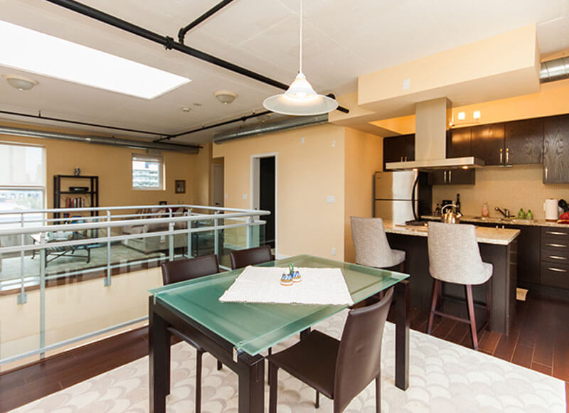 Steam Plant Lofts Showing Interior Dining Area with Kitchen in the Background